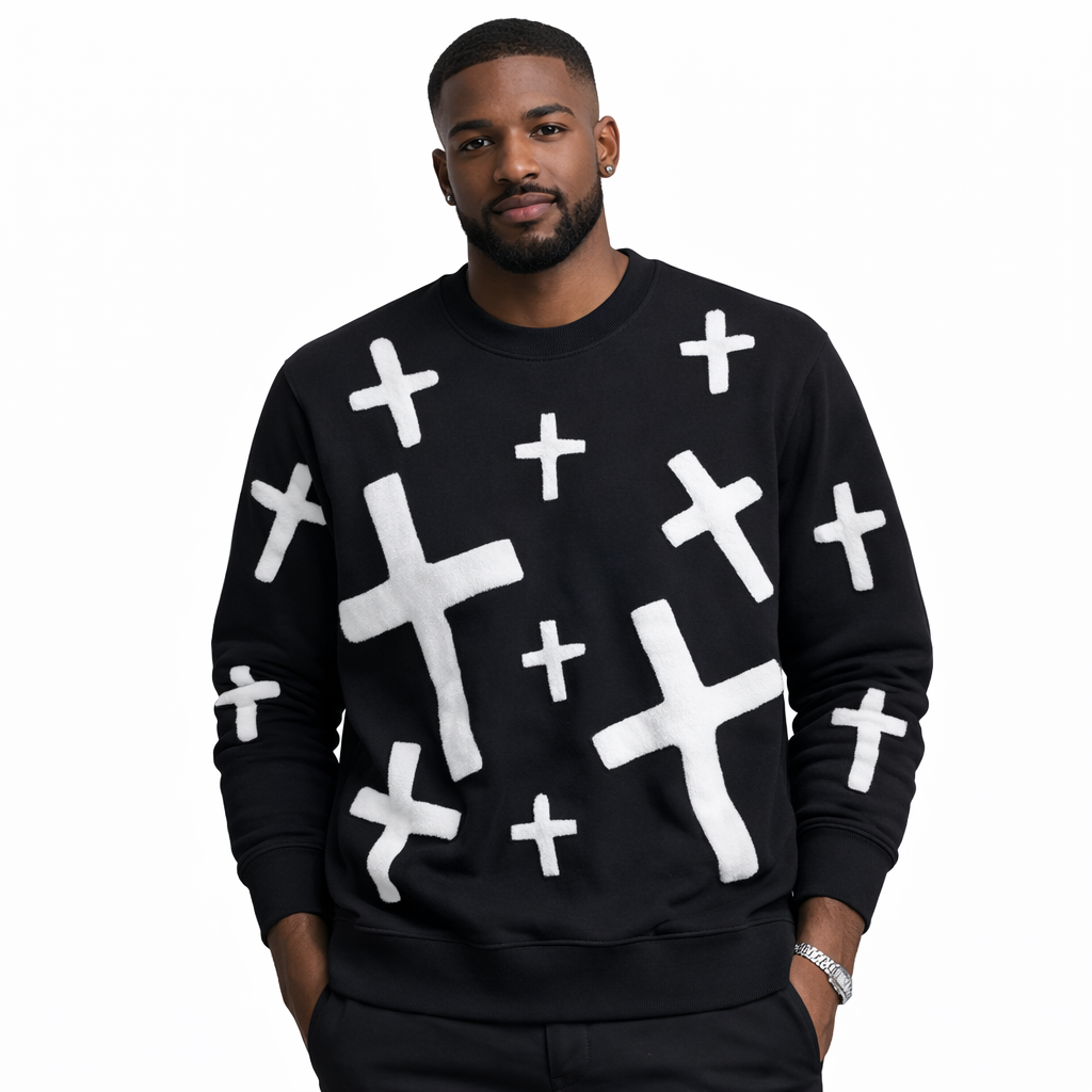 Man wearing a black gravity sweater with white cross patterns on a white background